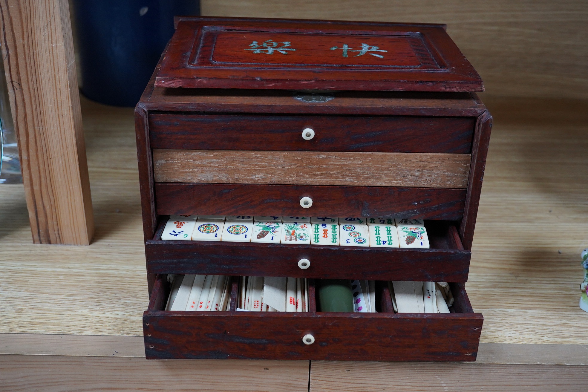 An early 20th century Chinese Mah Jong set, with bone tiles, 22cm x 15.5cm x 14.5cm. Condition - fair, one drawer front replaced